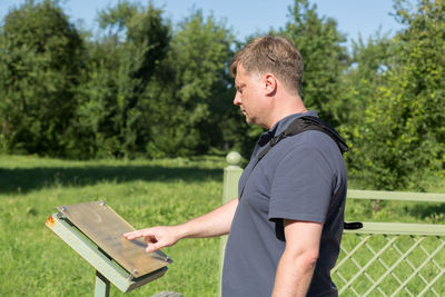 A european tourist reads the inscription on the memorial plaque of an asian cemetery.