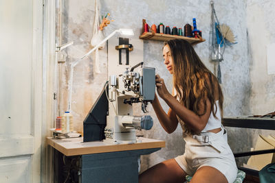 Fashion designer with sewing machine at workshop