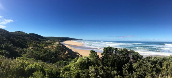 Scenic view of beach against clear blue sky