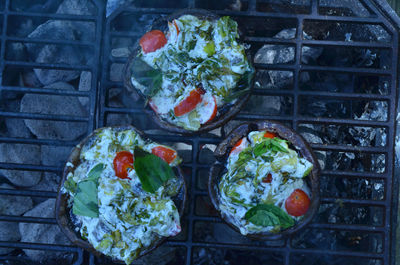 Grilling stuffed portobello mushrooms outdoors on hibachi grill