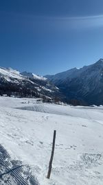 Scenic view of snow covered mountains against clear blue sky