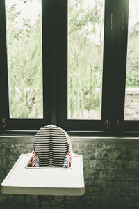 Empty high chair against window