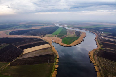 Aerial view of river amidst land against sky