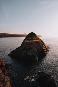 Rock formations in sea against sky