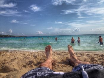 Low section of people relaxing on beach