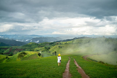 Rear view of man on field against sky