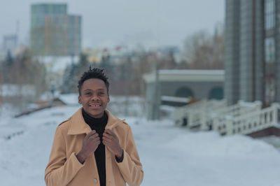 Young african american in winter against the backdrop of a majestic building