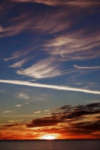 Scenic view of sea against dramatic sky during sunset