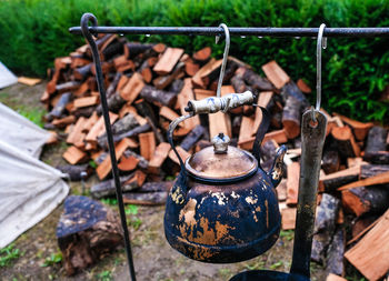 Close-up of rusty metal hanging on wood in field