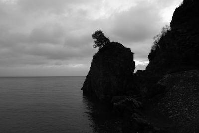 Rock formation in sea against sky