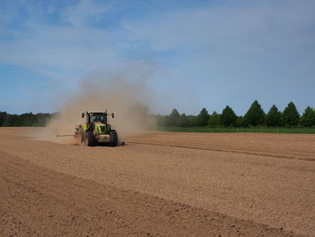 Tractor on agricultural field against sky