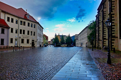 Street amidst buildings in town against sky