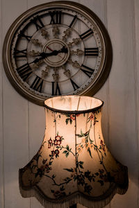 Close-up of clock against wall at home