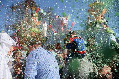 Rear view of people enjoying in water