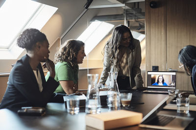 Businesswomen doing video conference with female colleague on laptop at office