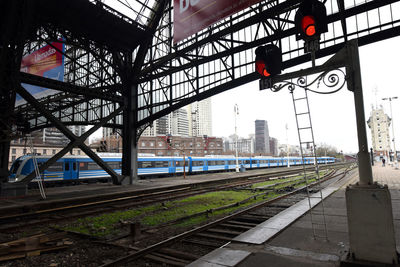 Railroad tracks in city against sky