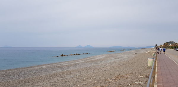 People on beach against sky