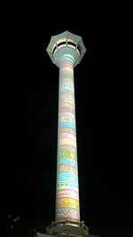 Low angle view of illuminated tower against sky at night