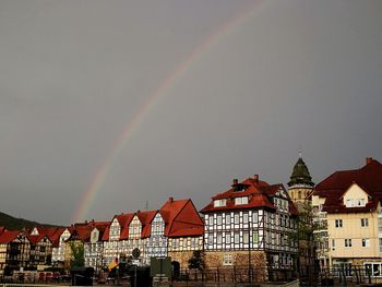 Low angle view of rainbow over buildings in city