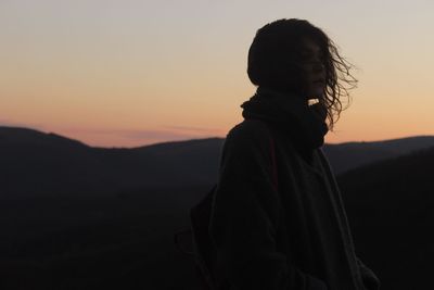 Silhouette of woman against sky during sunset