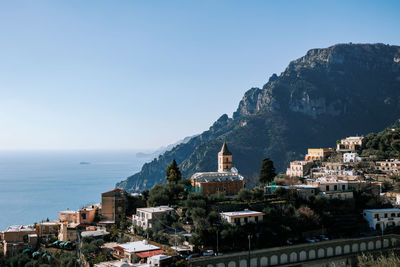 High angle view of townscape by sea against clear sky