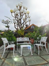 Empty chairs and table against sky