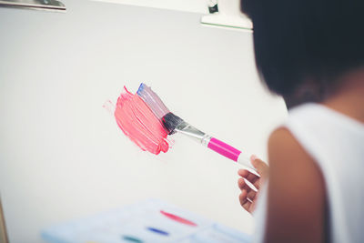 Cropped image of girl painting on canvas