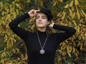 Young woman standing against plants