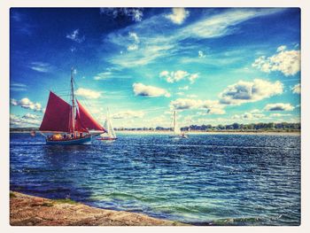 Boats in sea against cloudy sky