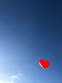 Heart shaped balloons against sky
