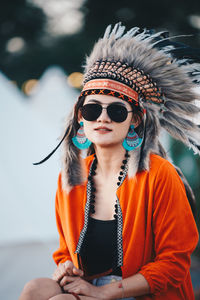Portrait of young woman wearing headdress while sitting outdoors