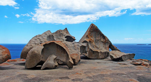 Rock formations on beach against sky