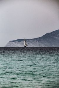 Sailboat sailing on sea against clear sky