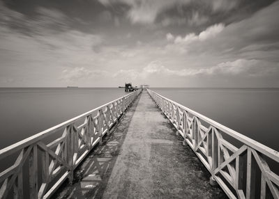 Empty pier on sea against sky