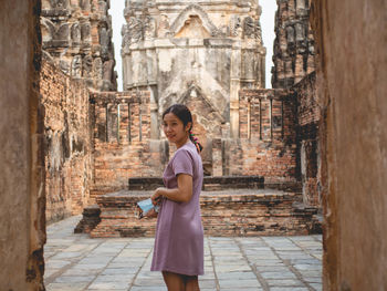 Full length of woman standing against old building