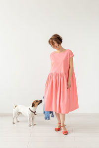 Woman with dog standing against white background