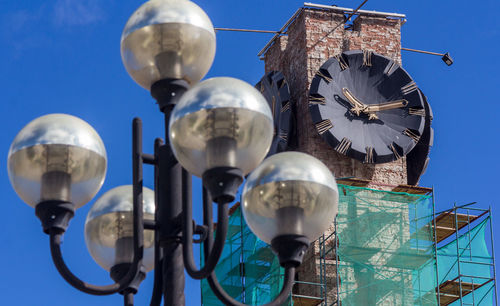 Low angle view of lighting equipment on building against sky