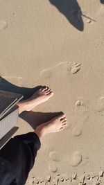 Low section of person standing on sand