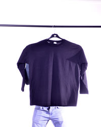 Rear view of clothes hanging on white background