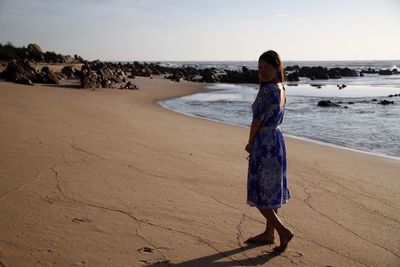 Side view of woman standing at beach