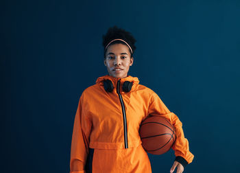 Portrait of boy standing against blue background