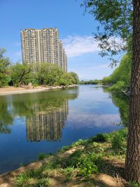 Scenic view of lake by buildings against sky