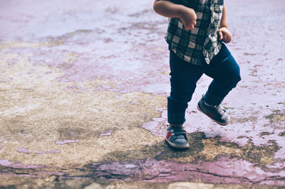 Low section of boy walking on floor