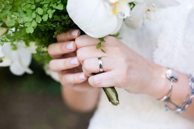 Midsection of bride holding flowers