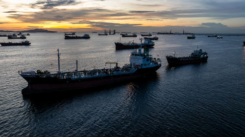 Boats in sea against sky during sunset