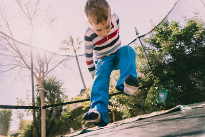 Low angle view of boy jumping at park