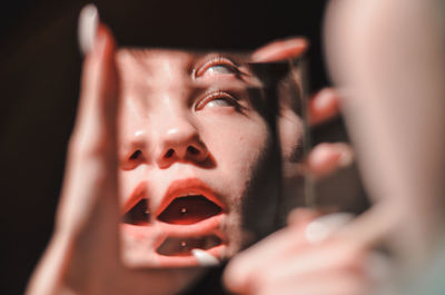 Close-up of woman reflecting on mirror