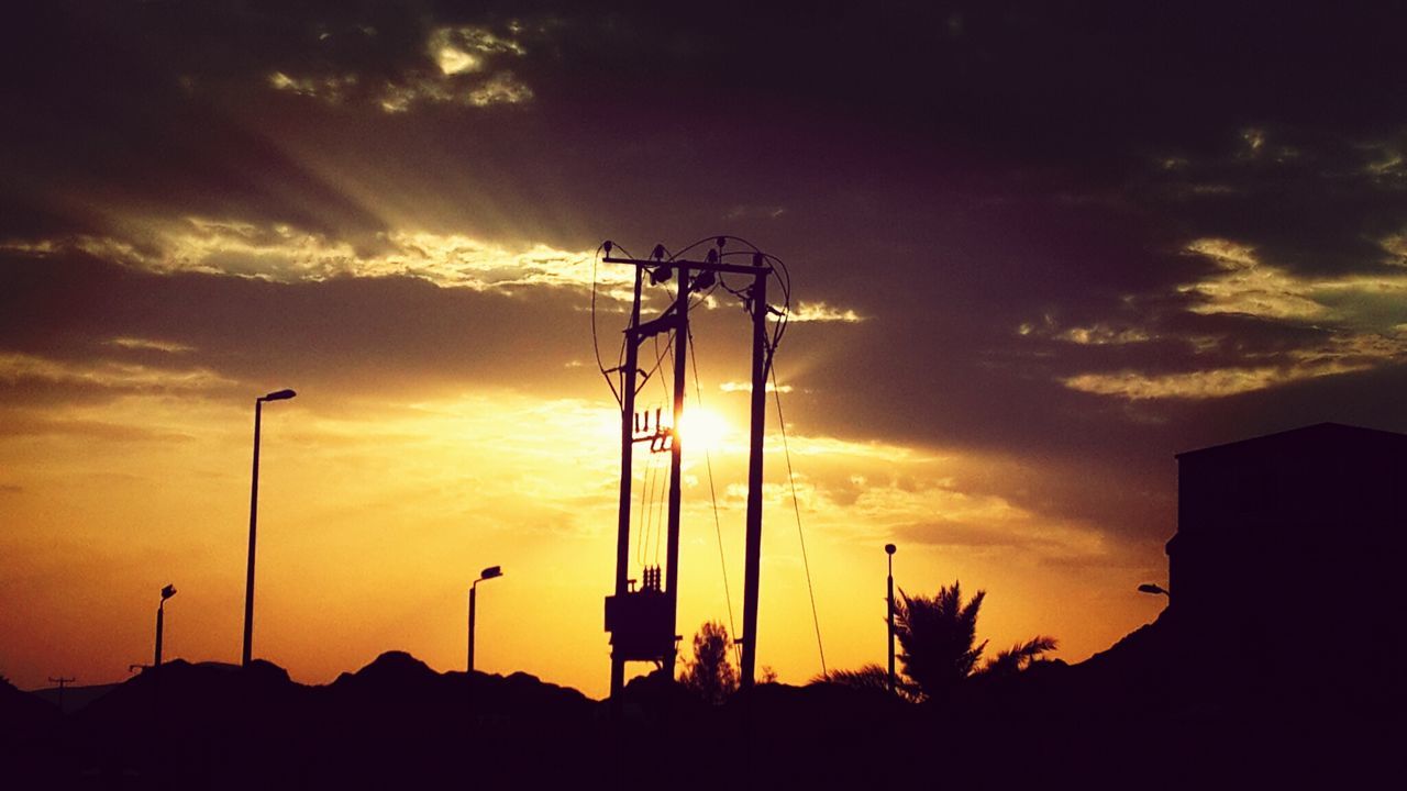 sunset, silhouette, sky, orange color, cloud - sky, street light, low angle view, beauty in nature, scenics, nature, tranquility, cloud, sun, tranquil scene, lighting equipment, dramatic sky, idyllic, outdoors, dark, no people