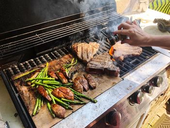 High angle view of person preparing food on barbecue grill