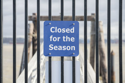 Close-up of warning sign on railing